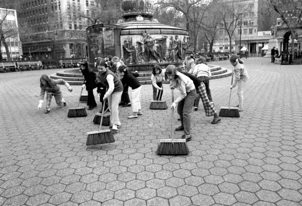 Trong ảnh, các nữ sinh New York quét dọn gần đài tưởng niệm ở công viên Union của thành phố.