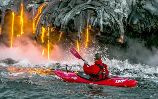Pedro Oliva mạo hiểm chèo thuyền tới gần dòng dung nham nóng đỏ trên hòn đảo Kauai,Hawaii.