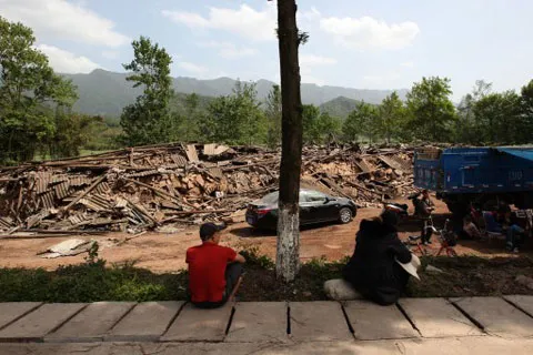 Người dân ở Longmen ngồi nhìn nhà cửa của mình nay đã biến thành một đống đổ nát sau trận động đất sáng 20/4.