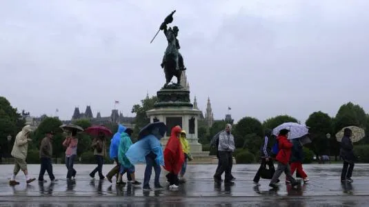 Khách du lịch đi dưới mưa ở Áo.