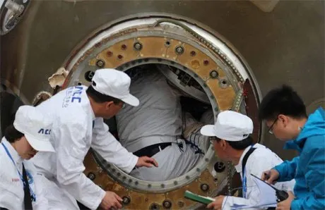 Các nhân viên hỗ trợ giúp các phi hành gia rời khỏi Thần Châu 10 sau khi tàu lao xuống khu vực Nội Mông vào sáng 26/6.