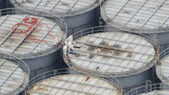 Các công nhân nhà máy Fukushima đang kiểm tra bể chứa nước nhiễm xạ. Mỗi bể cao khoảng 11m, chứa được 1000 tấn nước thải