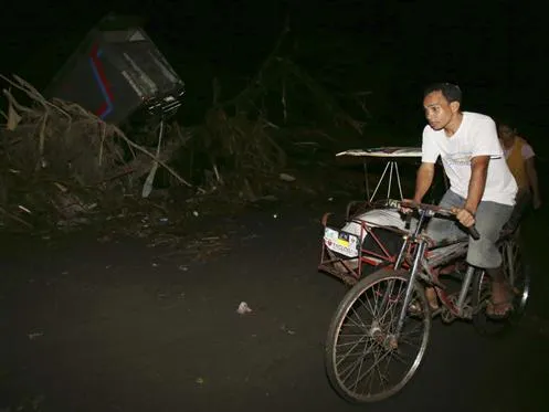 Sandy Torotoro, một người may mắn sống sót sau bão, đạp xe đi dọc một con đường tối tăm ở Tacloban.