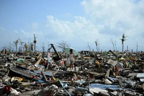 Một người phụ nữ bước qua đống hoang tàn ở thành phố Tacloban, miền đông Philippines, một trong những nơi chịu thiệt hại nặng nhất của siêu bão Haiyan