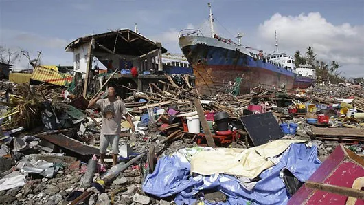 Người dân đi bên đống đổ nát sau bão Haiyan ở thành phố Tacloban, miền trung Philippines hôm 10/11