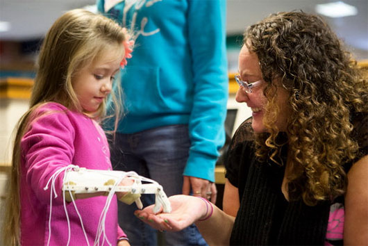 Bé Harmony Taylor điều khiển tay robot chạm tay dì của bé