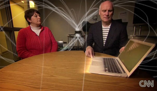 Tiến sỹ Katie Hall (áo đỏ bên trái) đang trình diễn laptop sạc điện mà không cần cắm vào ổ cắm điện