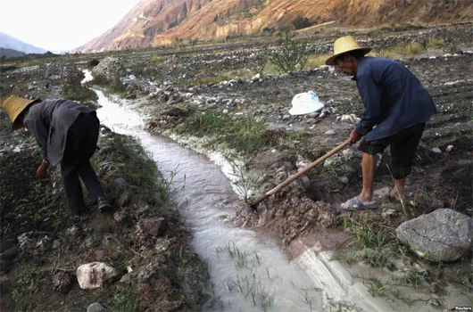 Nông dân đào mương để dẫn nước từ một dòng suối bị ô nhiễm vào các cánh đồng. Ảnh chụp tại Côn Minh, Vân Nam, tháng 3/2013.