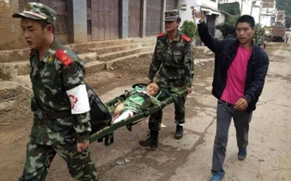 Đội cứu hộ đưa một em nhỏ bị thương đi cấp cứu sau trận động đất.