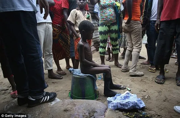 Cậu bé Saah Exco, 10 tuổi, đang sống trong một con hẻm phía sau khu ổ chuột West Point tại thành phố Monrovia, Liberia.