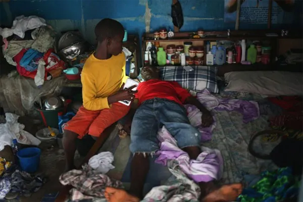 Một cậu bé chăm sóc bố nghi nhiễm Ebola trong chính ngôi nhà của họ.