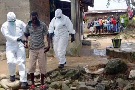 Các nhân viên y tế đang tháp tùng một người đàn ông nhiễm virus Ebola tới bệnh viện chữa trị ở Monrovia, Liberia.