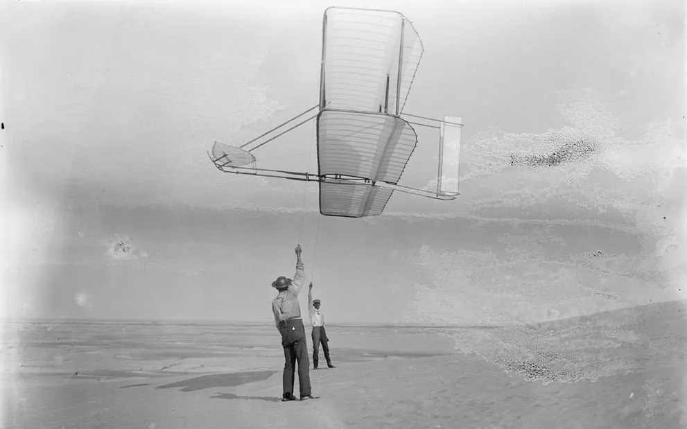 Bên trái là Dan Tate, và bên phải là Wilbur Wright, thả chiếu tàu lượn 1902, vào ngày 19/09/1902.