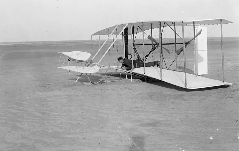 Wilbur Wright kiểm tra mức độ hư hại của máy bay Wright Flyer sau một lần thử thất bại, 14/12/1903, ở Kitty Hawk, North Carolina.