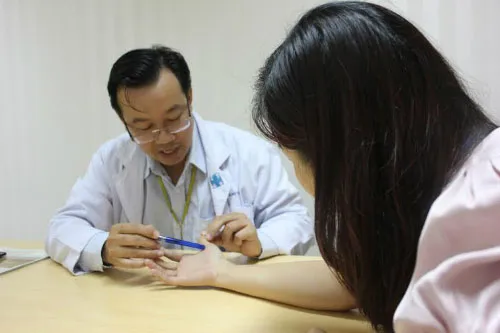 Bác sĩ Nguyễn Thành Nhân đang tư vấn điều trị cho một bệnh nhân bị ngón tay cò súng.
