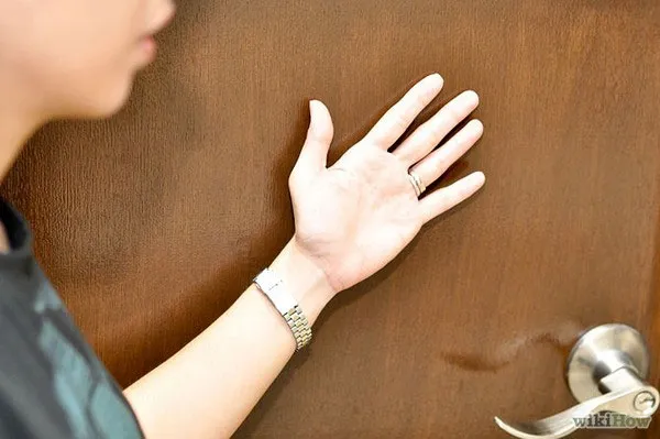 Cảm nhận sức nóng của cánh cửa bằng mu bàn tan.