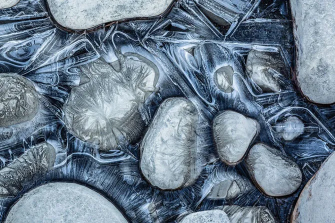 Mặt sông Athabaska đóng băng và những viên đá cuội ở công viên quốc gia Jasper, Canada trong mùa Đông.