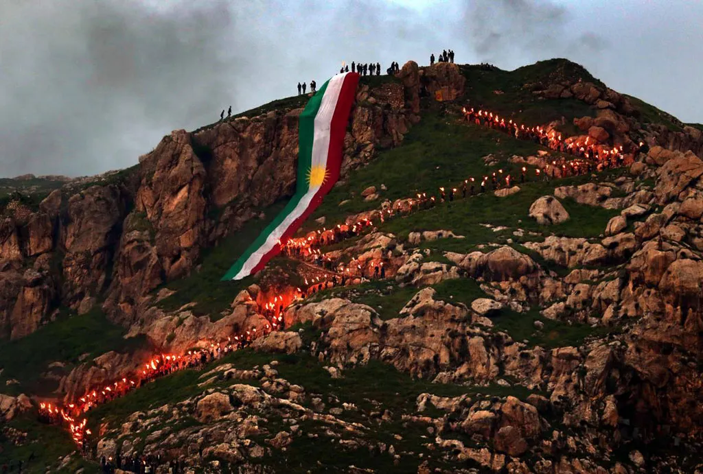 Người Kurd ở Iraq cầm đuối trên tay và đi lên núi với một lá cờ Kurdish lớn tại thị trấn Akra, cách thủ đô Baghdad 500km về phía Bắc, khi họ tổ chức lễ hội mùa Xuân Noruz