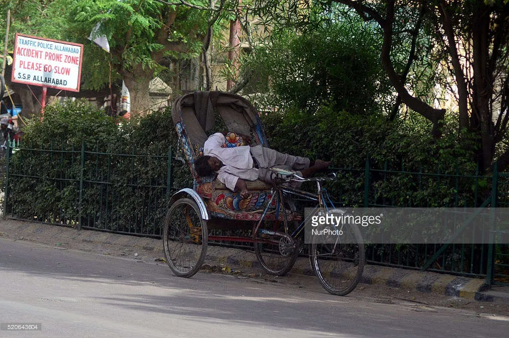 Người đàn ông tranh thủ nghỉ ngơi sau những giờ làm việc nặng nhọc dưới thời tiết nắng nóng khắc nghiệt ở Allahabad, Ấn Độ.