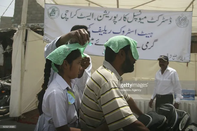 Người tham gia giao thông ở Karachi, Pakistan đội khăn ướt chống nắng.