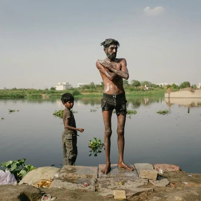 Một người đàn ông và một cậu bé tắm ở sông Yamuna.