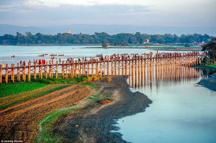 Các nhà sưu đi qua cây cầu U Bein, bắc ngang qua hồ Taungthaman gần Amarapura, Myanmar.