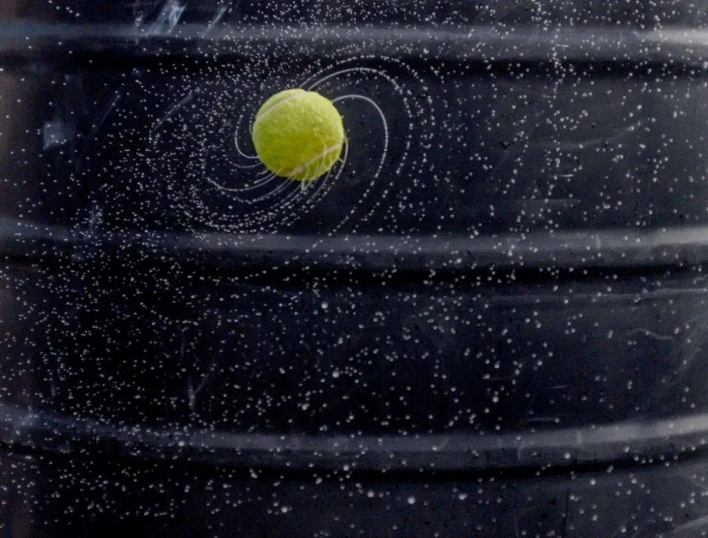 Tình cờ quả bóng tennis lại trông giống một hành tinh vĩ đại trong dải ngân hà được bao quanh bởi triệu triệu ngôi sao nhỏ.