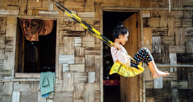 Sanjanai Kharrymba, 6 tuổi, chơi đùa trên chiếc xích đu tái chế ở trước cửa nhà.