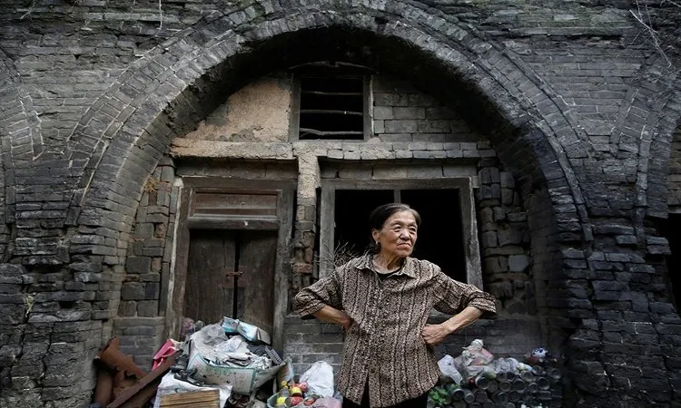 Bà Li Yonghua, 65 tuổi, đứng trước ngôi nhà bị hư hỏng tại khu vực sụt lún nằm cạnh một mỏ than ở làng Helin, ngoại ô thành phố Xiaoyi, tỉnh Sơn Tây.