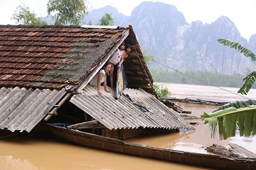 Nhà bị ngập sát mái nhưng chị Trần Thị Hoa vẫn trụ lại để trông giữ tài sản khỏi bị lũ cuốn trôi.