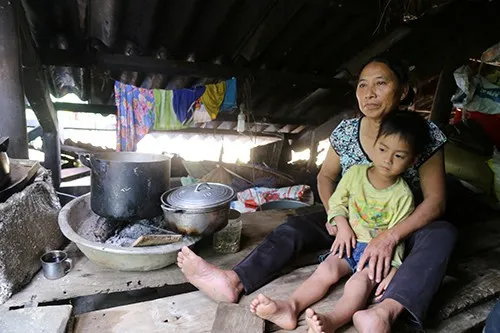 Bà Cao Thị Xuyên kê mấy thanh gỗ sát mái nhà để tránh lũ. Bữa cơm giữa lũ ăn với muối trắng.