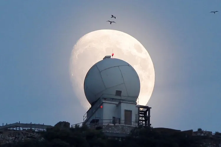 Trăng rằm dần xuất hiện trên nóc một tháp quan sát tại vùng lãnh thổ Gibraltar của Anh.