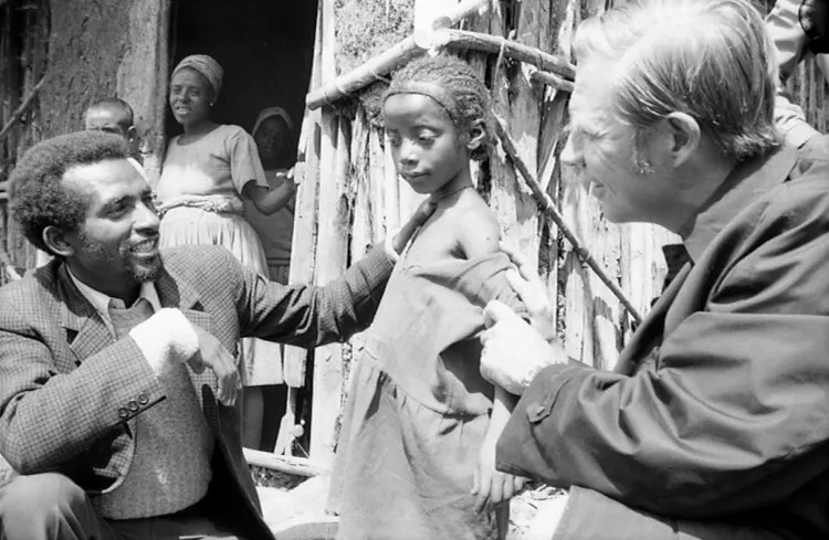 Bác sĩ Henderson kiểm tra vết sẹo tiêm chủng trên tay một cô bé Ethiopia.