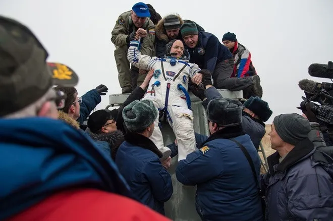 Phi hành gia Scott Kelly của NASA được đỡ ra khỏi tàu vũ trụ Soyuz TMA-18M
