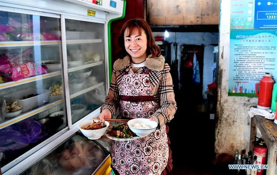 Cô Qing Ningling, chủ một quán trọ địa phương, chuẩn bị bữa trưa sau khi đón khách du lịch tới làng.