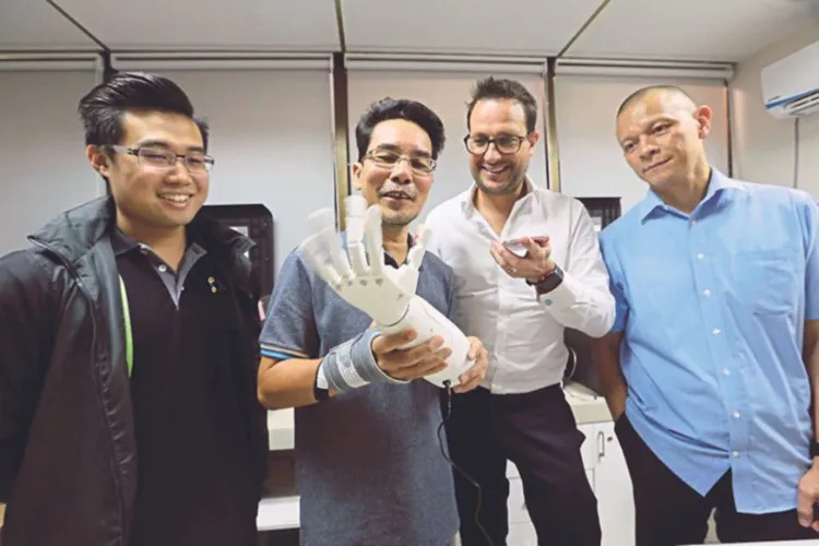 Sujana Rejab cầm một cánh tay giả trong văn phòng ở tháp Faber, Kuala Lumpur.