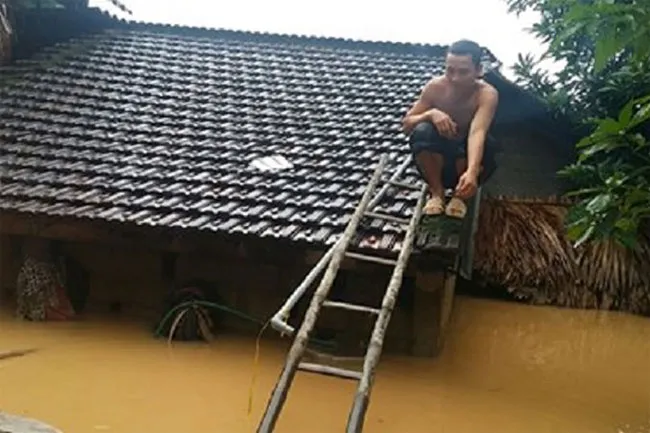 Hình ảnh người dân trèo lên nóc nhà tránh cảnh mưa lũ ở Quảng Bình.