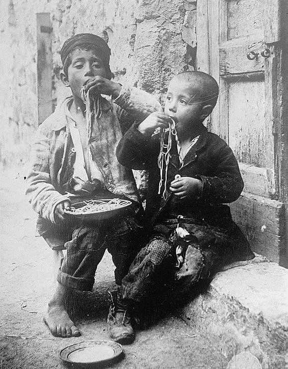 Hai đứa trẻ ngấu nghiến món mỳ Ý được chụp vào năm 1900.